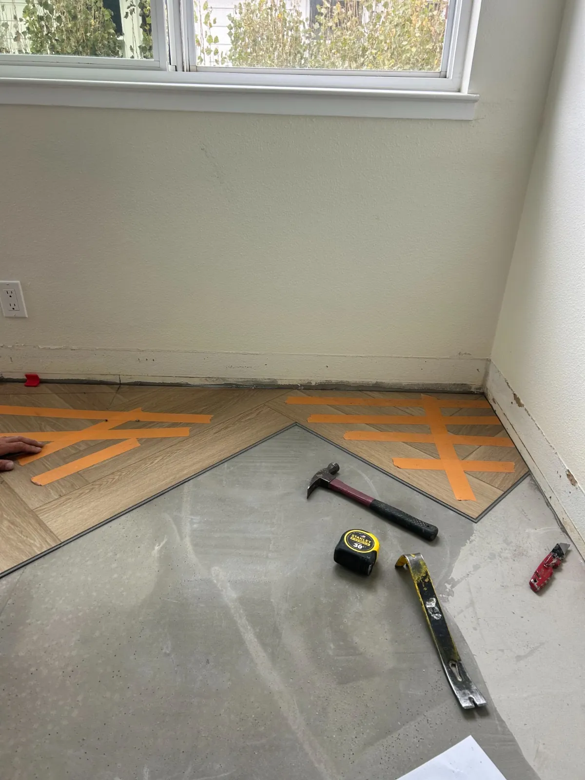 Partially laid herringbone floor with tools