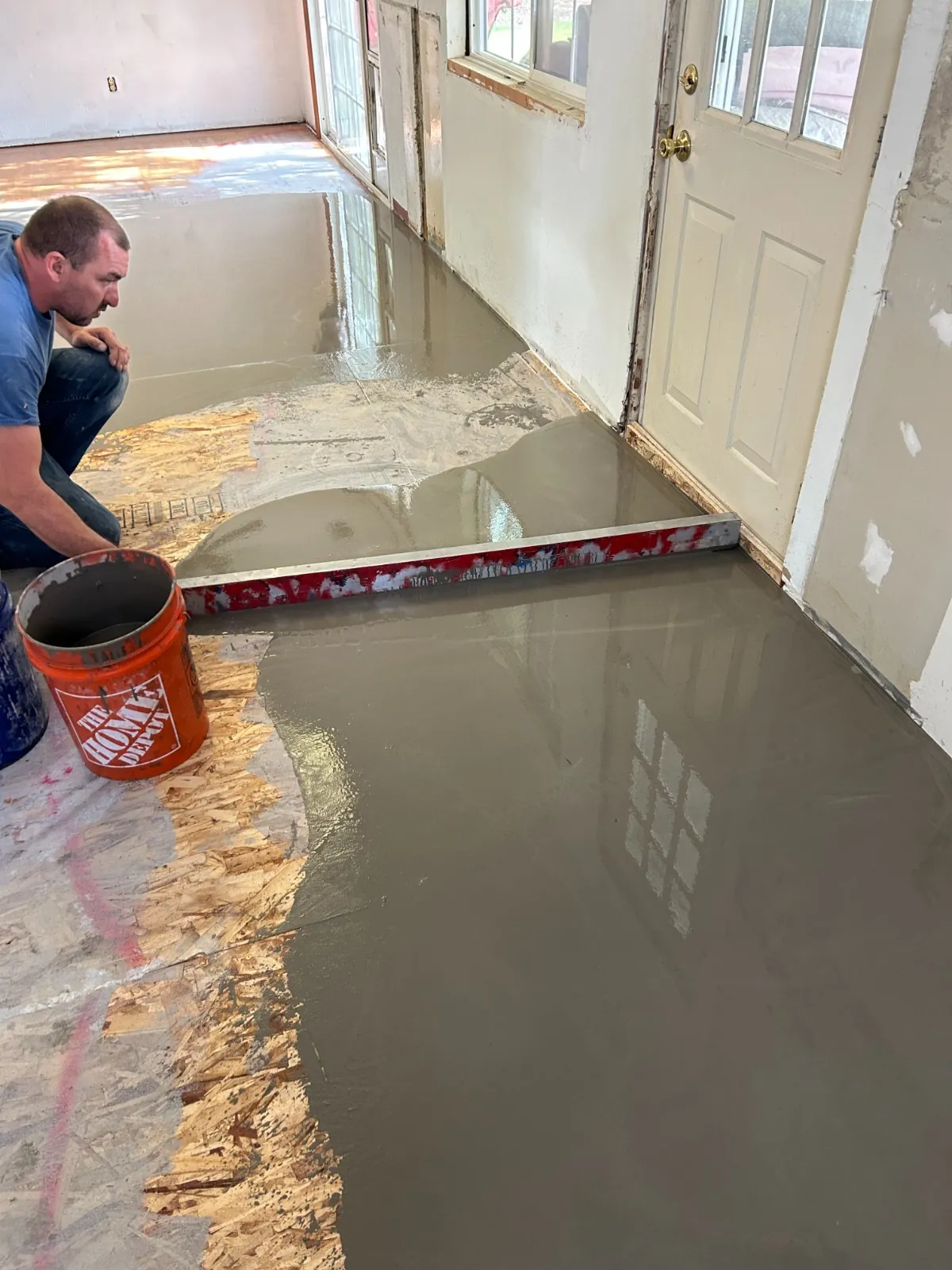 Craftsman spreading compound across the floor
