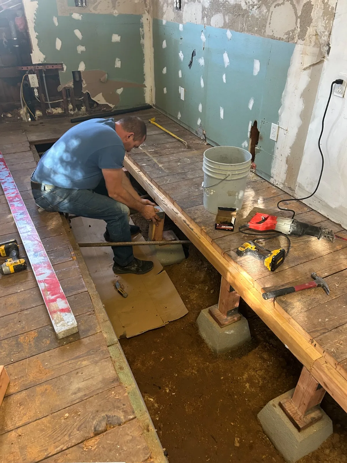 Flooring craftsman working on exposed subfloor framing