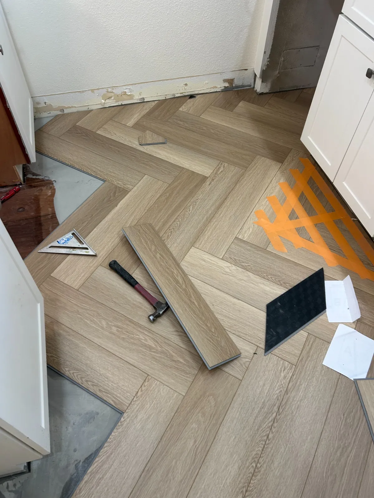 Herringbone layout lines and tools on a subfloor