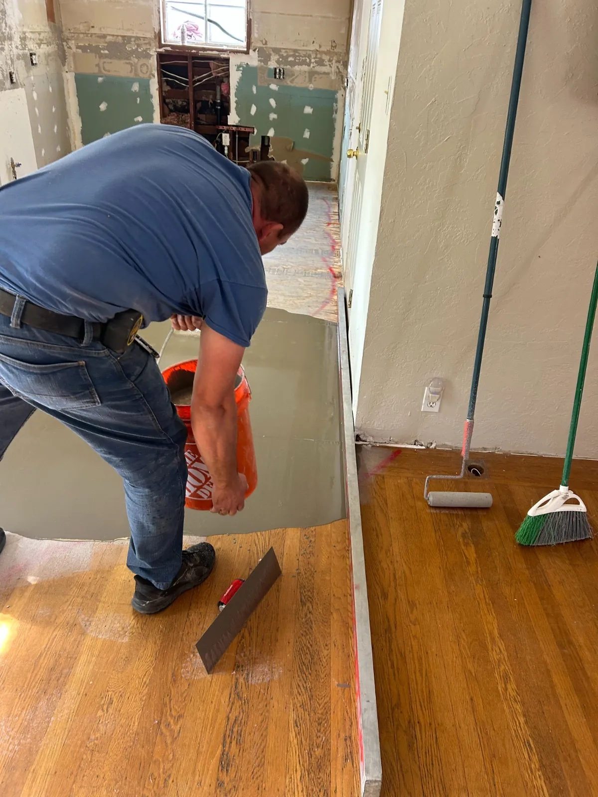 Craftsman working on plank flooring during installation